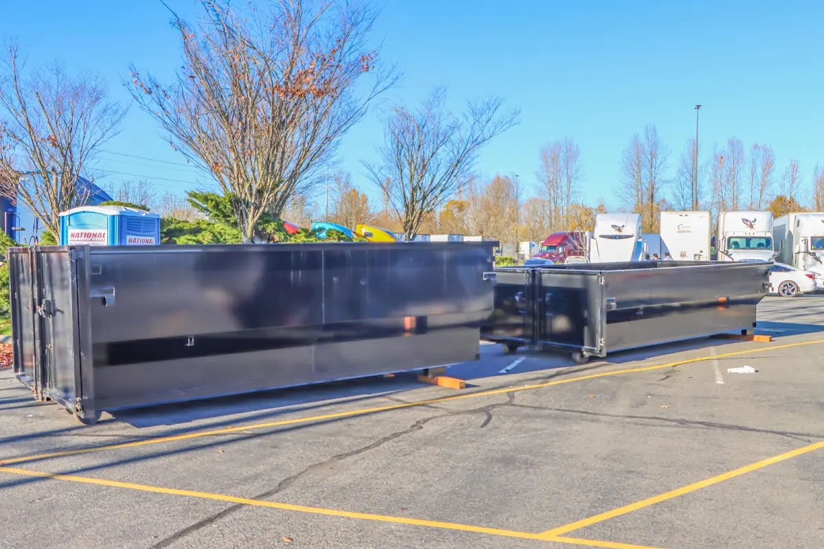 Professional dumpster rental service with roll-off container on residential driveway in Holly